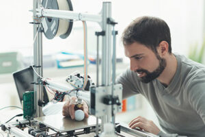Young designer engineer using 3D printer