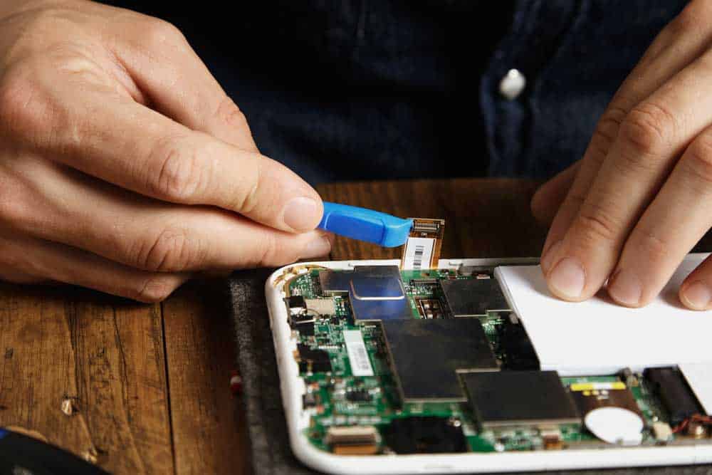 A man opens a phone to reveal a motherboard