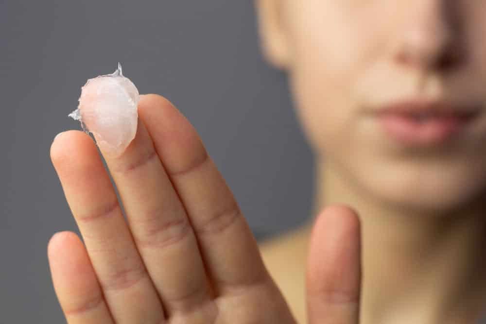 A young woman using petroleum jelly